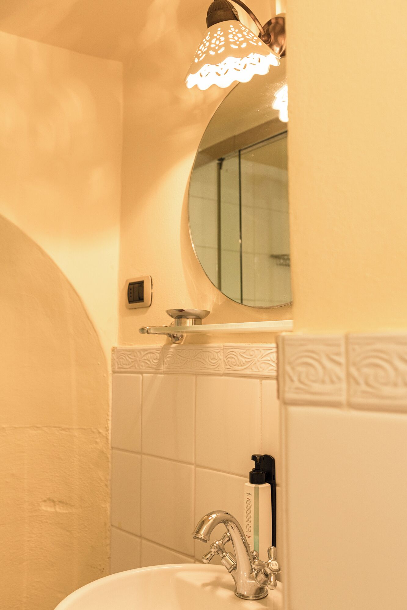Een badkamer met een wastafel, spiegel en douche.