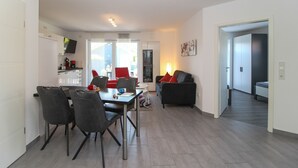 Eine moderne Wohnung mit Essbereich, Wohnzimmer und Küche.