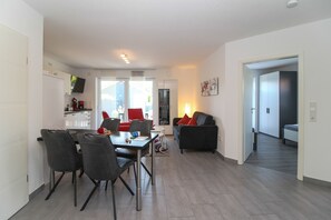 Un appartement moderne comprenant un coin repas, un salon et une cuisine.