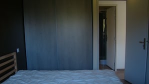 A bedroom with a bed, a wardrobe, and a door leading to a bathroom. - House with terrace, Avignon festival 12km away, Spirou park and wave island (Le Thor)