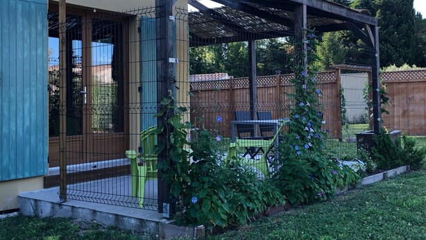 A covered patio area with a wooden pergola, a fenced garden, and a seating area with chairs. - House with terrace, Avignon festival 12km away, Spirou park and wave island (Le Thor)