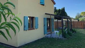 A two-story house with blue shutters, a covered patio, and a fenced backyard. - House with terrace, Avignon festival 12km away, Spirou park and wave island (Le Thor)