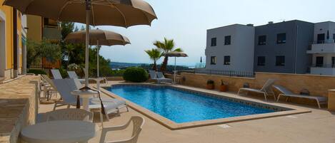 Seasonal outdoor pool, open 9:00 AM to 9:00 PM, pool umbrellas