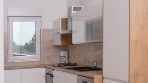Una cocina moderna con armarios blancos, encimera de madera y lavavajillas integrado.