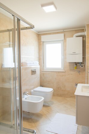 Een douche, een haardroger, een bidet, handdoeken