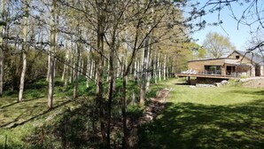 Una casa moderna con base de piedra, rodeada de un área boscosa.