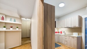 A modern kitchen with wooden cabinets, a countertop, and a view to the outside. - Acropolis Promenade Apartment (Athens)