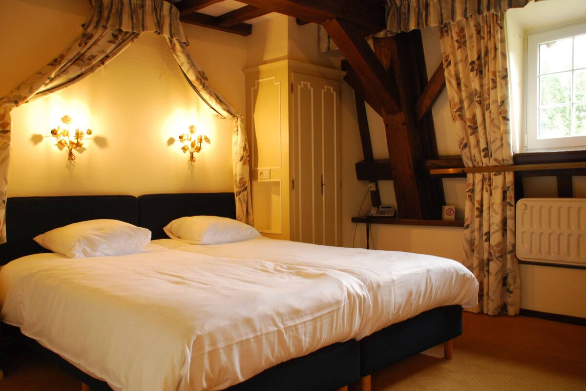 Un dormitorio con cama a dosel, mesita de noche y radiador.