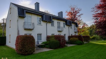 Une maison à deux étages avec un jardin.