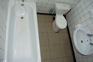 Une salle de bain avec une baignoire, des toilettes et un lavabo.