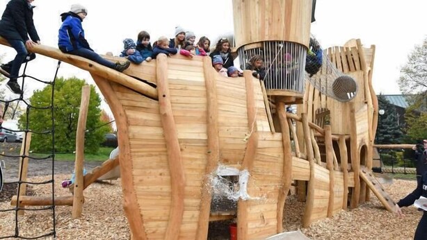 A wooden play structure with a slide and climbing elements. - Gästezimmer  Weingut Peter (Wachenheim an der Weinstrasse)