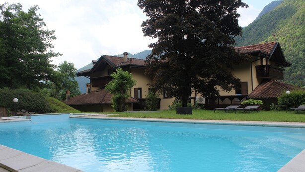 Una piscina con vistas a edificios tradicionales y un telón de fondo montañoso.