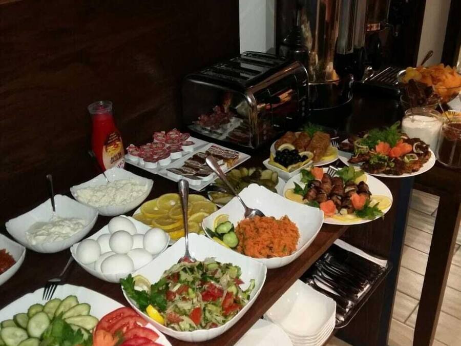 Un bufé con diversos alimentos, entre ellos ensaladas, huevos y platos de carne.