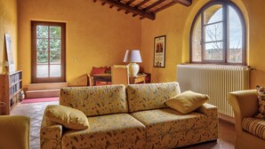 Een gezellige woonkamer met een bank, fauteuils, een tafel en een raam met uitzicht.