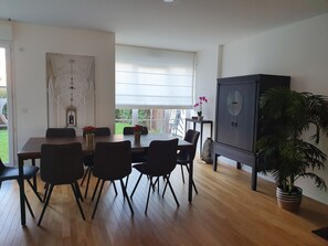 Un comedor con una mesa y sillas de madera, un mueble aparador y una planta en maceta.