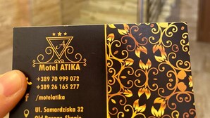 A business card for Motel Atika with contact numbers and location details.