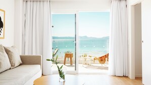 Una habitación con sofá, una mesita de centro y vista a la playa a través de un ventanal.