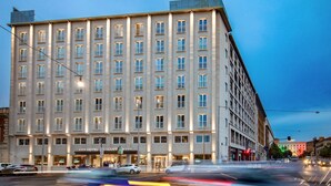 Un hotel de varios pisos con fachada simétrica, ventanas amplias y una entrada destacada.