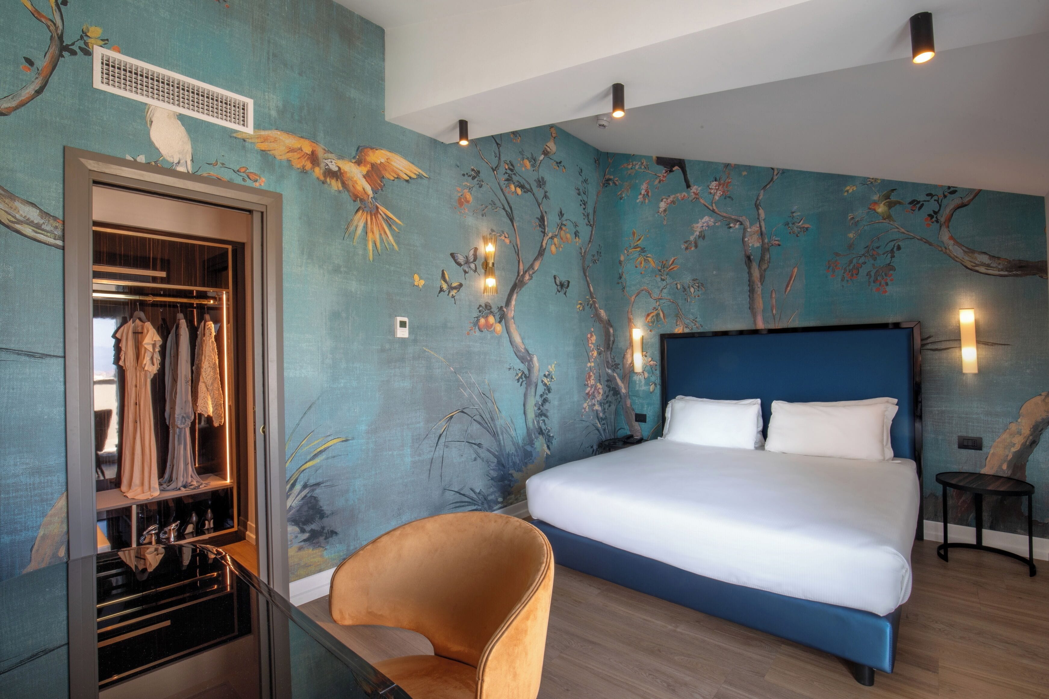 A bedroom with a large bed, a wardrobe, and a chair.