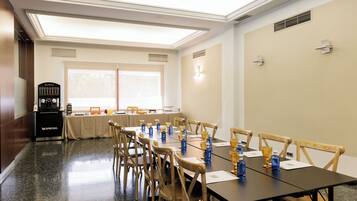A conference room with a long table, chairs, and a coffee station.
