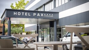 Een moderne hotelentree met een bordje met de tekst 'HOTEL PAX GUADALAJARA'.