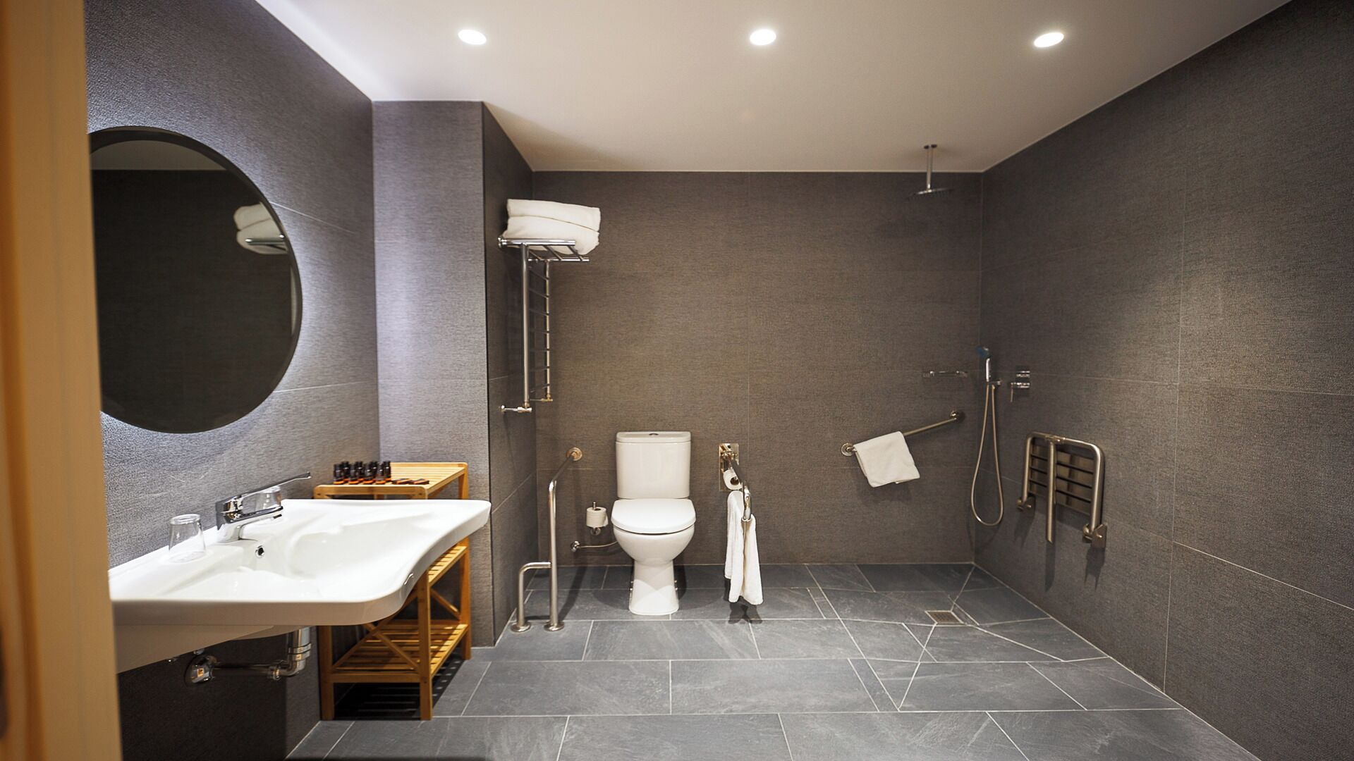 A modern bathroom with a sink, toilet, and shower.