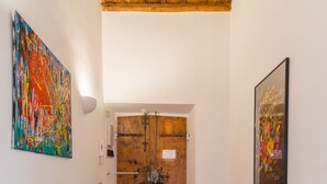 Un couloir avec un plancher en bois, une armoire rouge et deux portes.