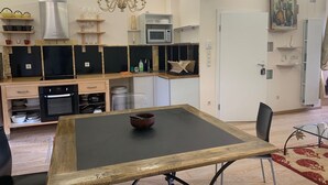 A modern kitchen with a dining table, microwave, and various kitchen appliances. - Beautiful 1Bd Duplex close to the Pétrusse and the City Historical center (Luxembourg)