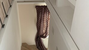 A staircase with a patterned curtain hanging on the right side. - Beautiful 1Bd Duplex close to the Pétrusse and the City Historical center (Luxembourg)