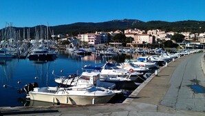 A marina with boats docked along a waterfront, buildings in the background, and a clear sky. - MINI VILLA 60m² with swimming pool - 2 bedrooms - air-conditioned - terrace - beach 5 mins (Travo VENTISERI)