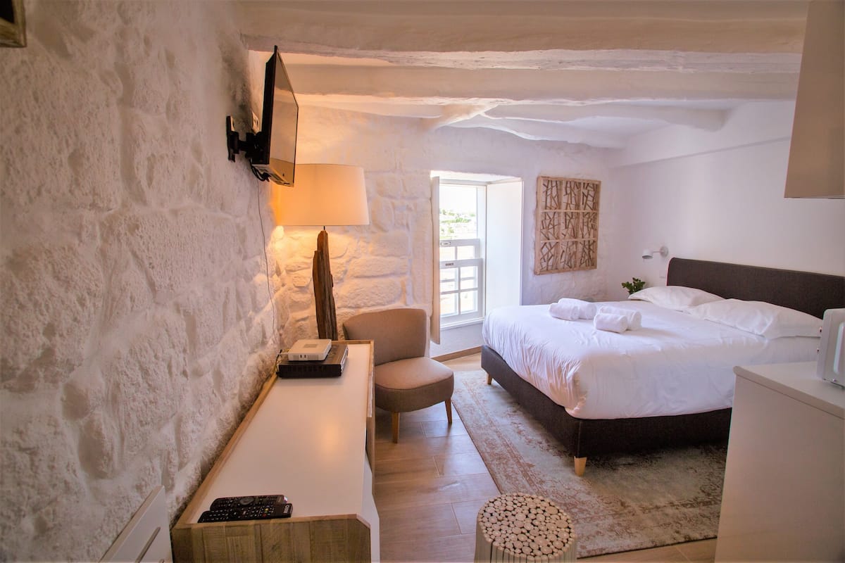 Ein Schlafzimmer mit einem Bett, einem Schreibtisch, einem Stuhl und einer Lampe.