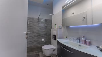Kamar Deluks (2) | Kamar mandi | Shower, handuk, sabun, dan tisu toilet