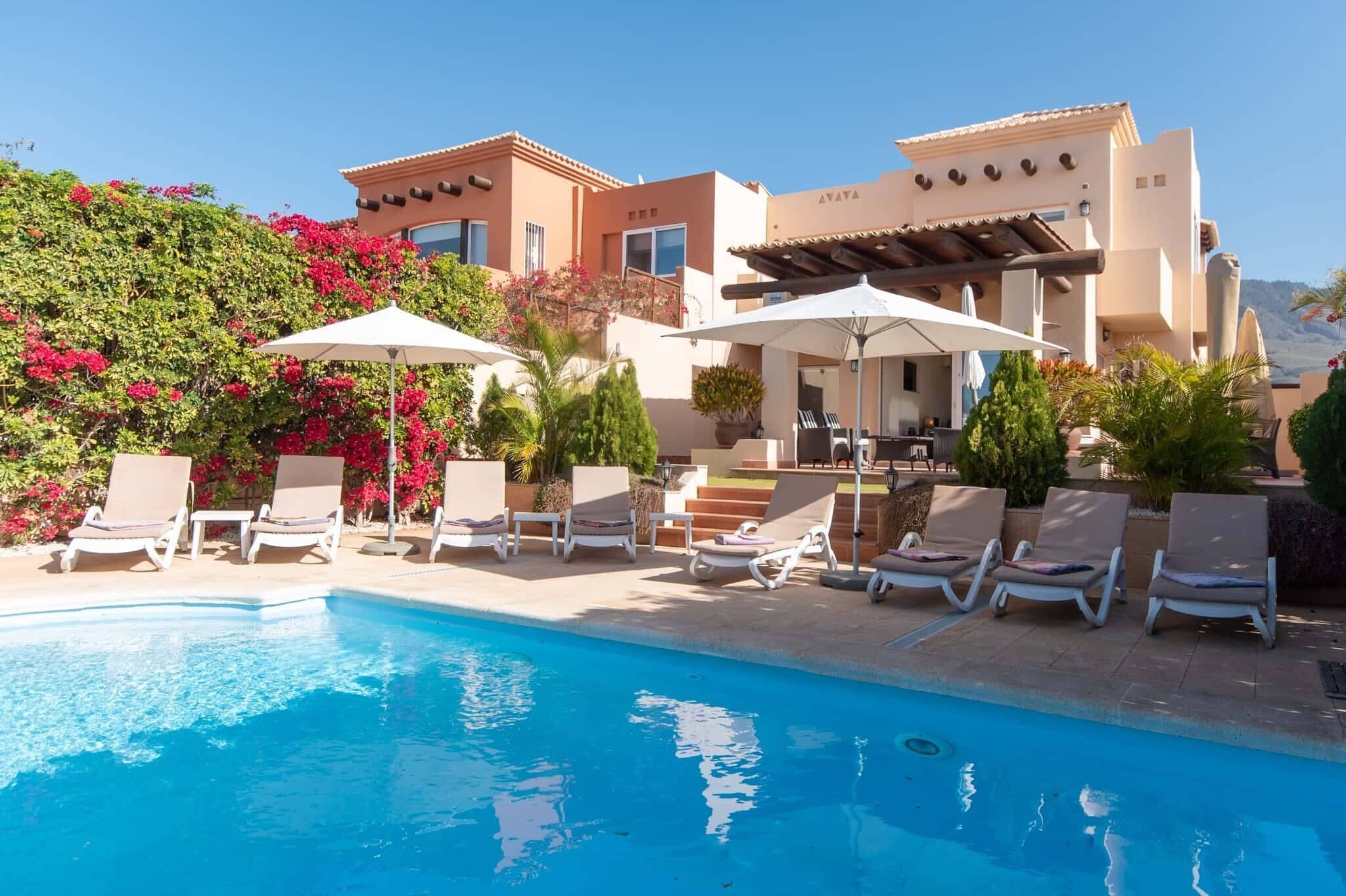 Een buitenzwembad, een verwarmd zwembad en ligstoelen