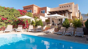 Een buitenzwembad, een verwarmd zwembad en ligstoelen