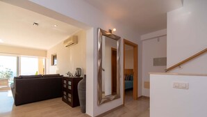 Un salón espacioso con un sofá, un espejo grande y una escalera.