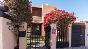 Una entrada protegida con letrero de número, buzón y puerta con el letrero 'W'.