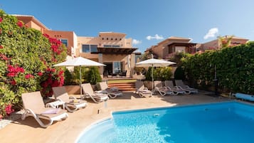 Een buitenzwembad, een verwarmd zwembad en ligstoelen