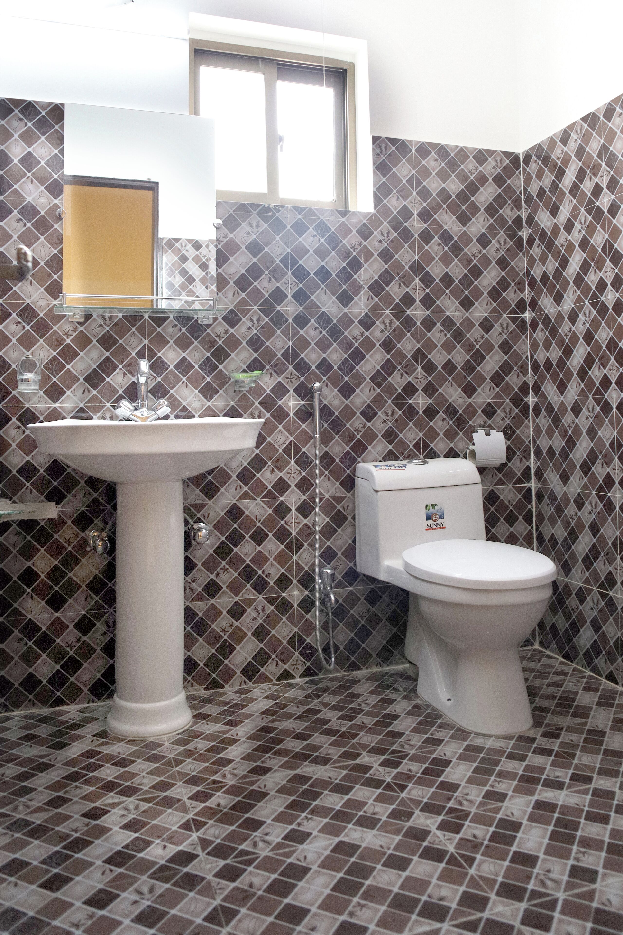 A bathroom with a sink, toilet, and a window.