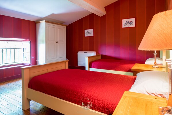 A room with two beds, a wardrobe, a radiator, and a window with a view. - La Maison Vigneronne (Trebes)