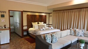 A hotel room with a bed, a sofa, a dining area, and a bathroom. - Lamor Guest House (Middelburg)