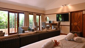 A hotel room with a large bed, a sofa, a desk with a TV, and a balcony with chairs. - Lamor Guest House (Middelburg)