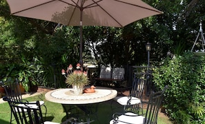 An outdoor patio with a round table, chairs, and an umbrella. - Lamor Guest House (Middelburg)