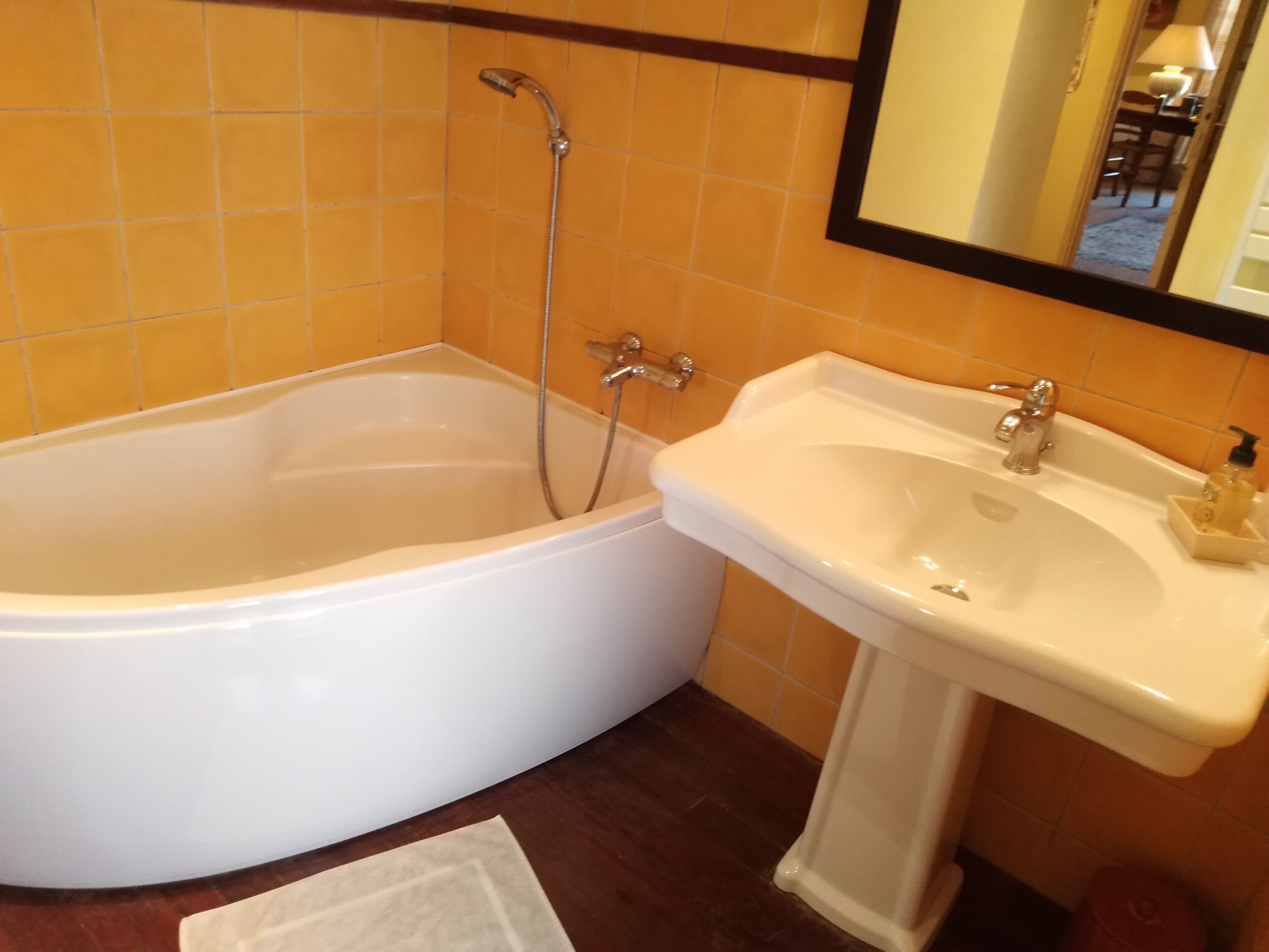 A bathroom with a bathtub, a sink, and a mirror.