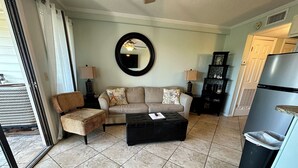 A living room with a sofa, armchairs, a coffee table, a mirror, and a refrigerator. - Beach Happy!-Nice ocean view Hilton Head Villa (Hilton Head Island)