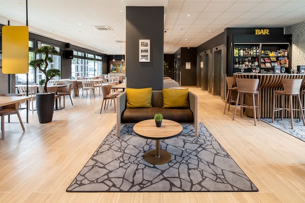 Un área lounge moderna con bar, disposición de asientos y una alfombra decorativa.