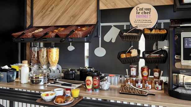 Un bufé de desayuno con diversas opciones de comida, salsas y una estación de café.