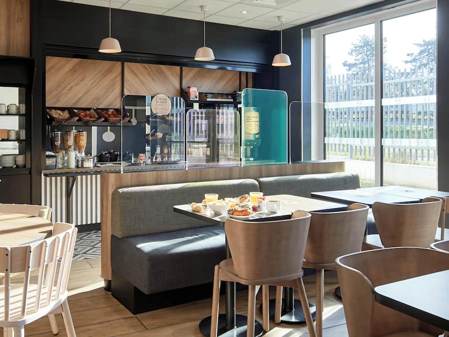 Een modern restaurant met een bar, zitplaatsen en uitzicht op het omliggende gebied.