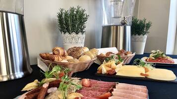 Eine Auswahl an Lebensmitteln, darunter Brot, Käse und Fleisch, auf einem Tisch angerichtet.