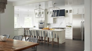 A modern kitchen with white cabinetry, a central island, and bar stools. - Fabulous Oceanview Palmetto Dunes
6 Bedrooms 7 Bathrooms (Hilton Head Island)