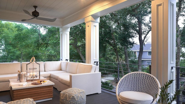A covered outdoor seating area with a white sofa, wicker chairs, and a wooden coffee table. - Fabulous Oceanview Palmetto Dunes
6 Bedrooms 7 Bathrooms (Hilton Head Island)